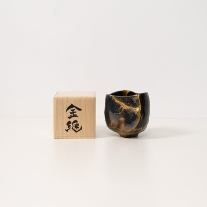 "Eine schwarze Kintsugi-Matcha-Schale steht neben einer japanischen Geschenkbox aus Holz, die widerstandsfähige Keramikkunst zeigt"