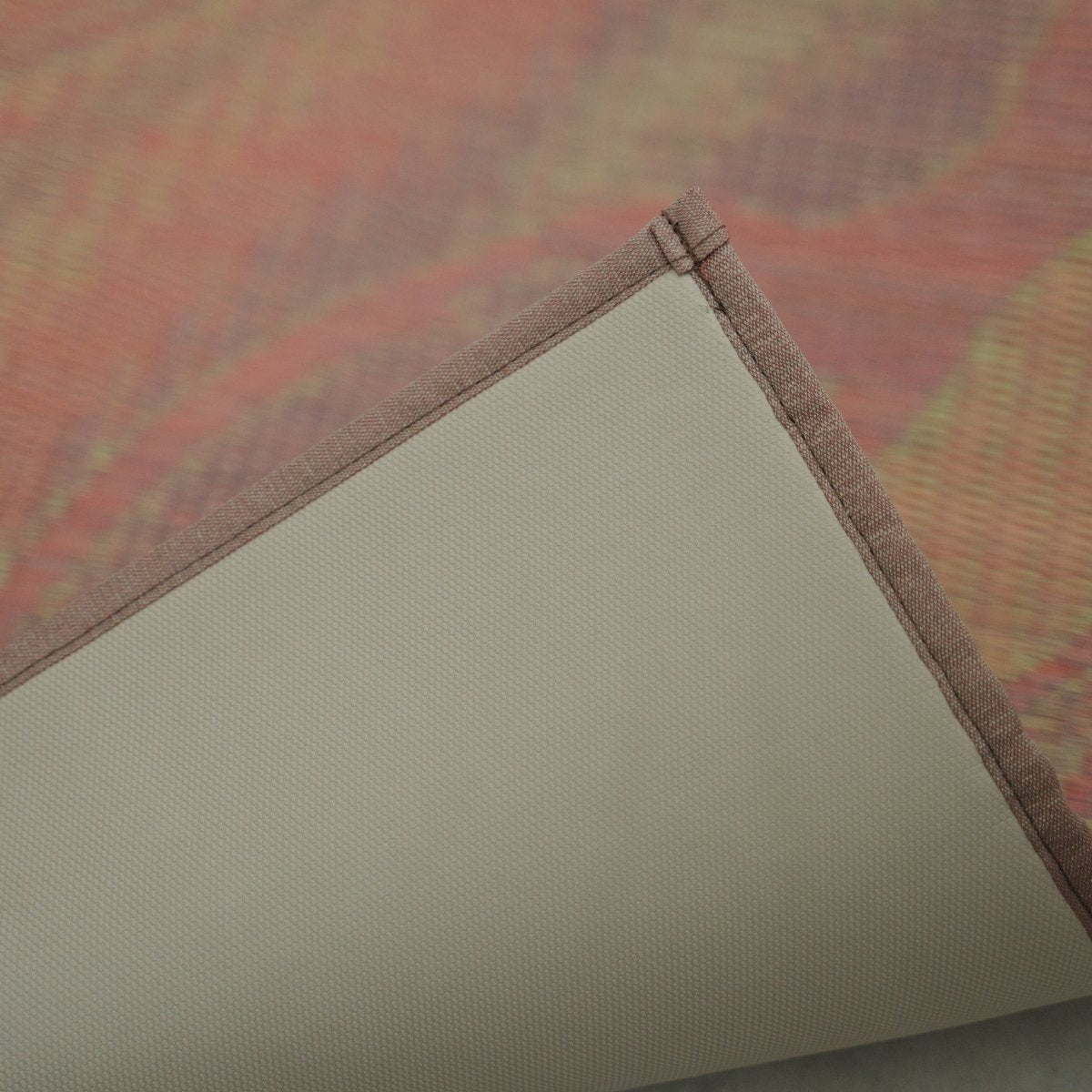 Corner of the Japanese Tatami Yoga Mattress "Marble" Pink lifted to reveal the non-slip TPE backing and stitched border.