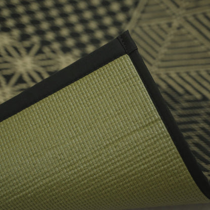 Hoek van de Japanse Tatami Yoga Matras "Ed Plain" Zwart opgetild om de getextureerde PVC-achterkant en zwarte rand te tonen.
