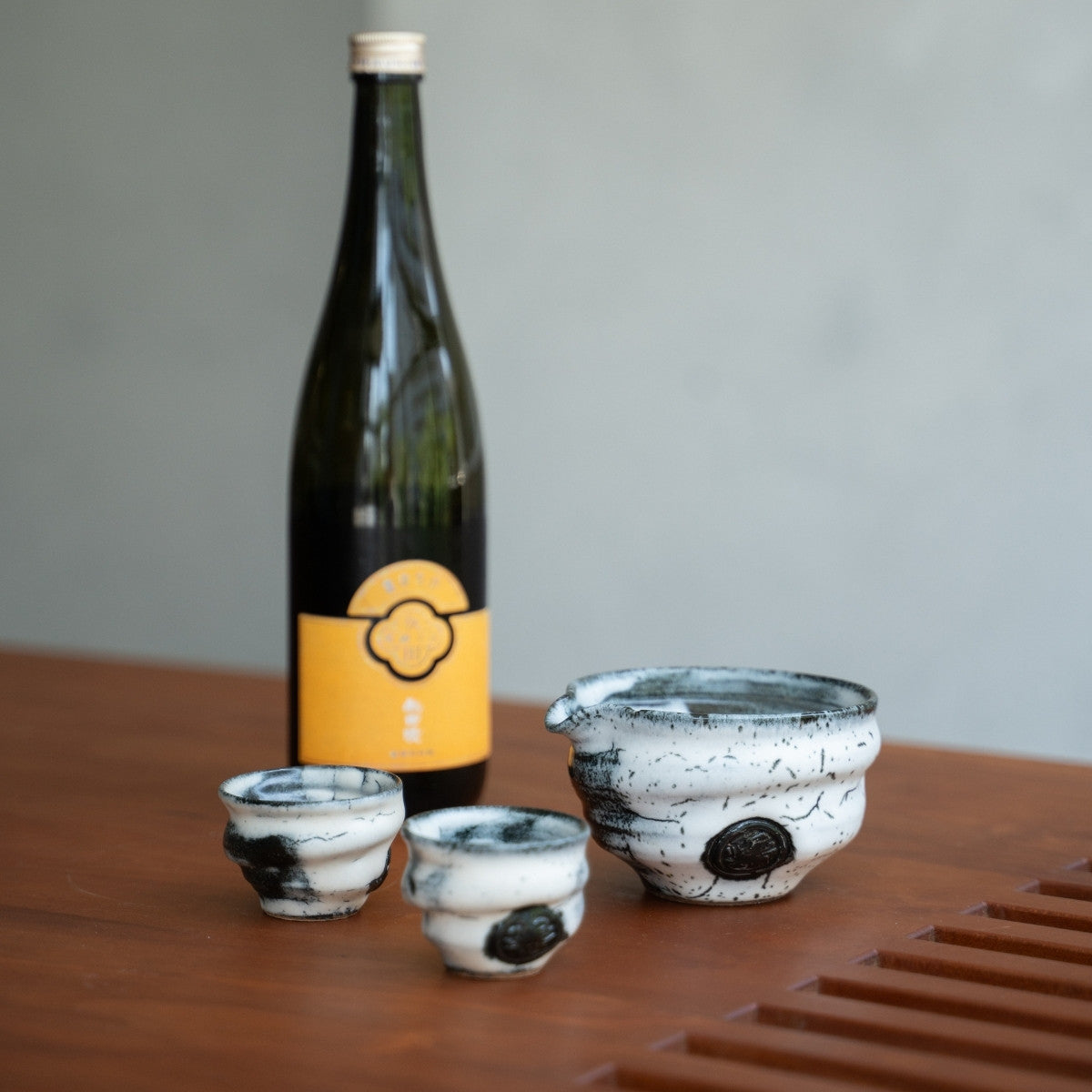 Creative Cloud Japanese sake set with a carafe and cups next to a sake bottle, ideal as a premium gift for sake lovers