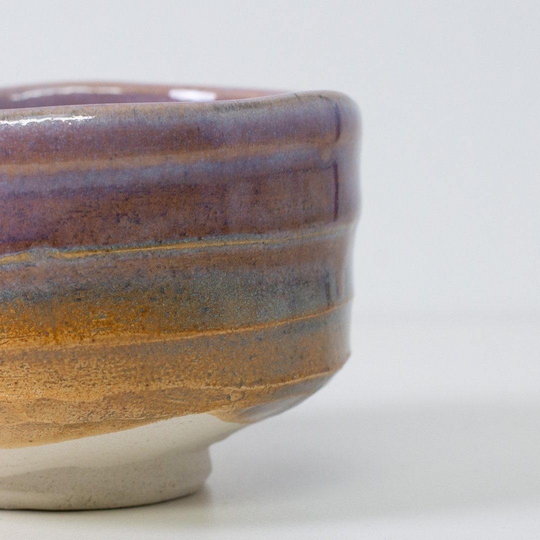 Detalje af "Pale Violet Haze" matcha-skål, der fremhæver den organiske gradient, hvor lilla glasur møder den teksturerede Shino-ler.