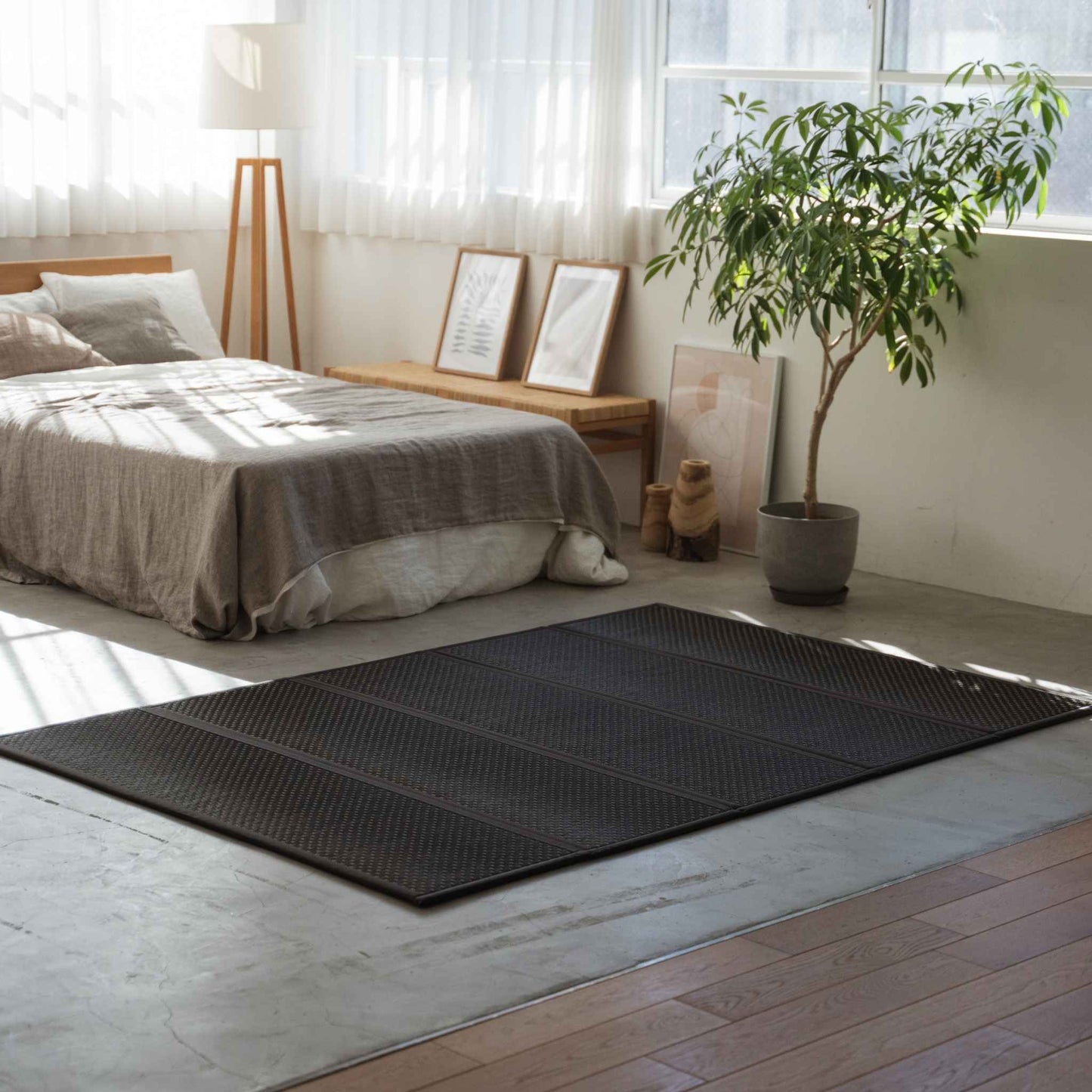 Dobbelt sort tatami-madras lagt på et soveværelsesgulv, der skaber et stilfuldt og åndbart soveområde.