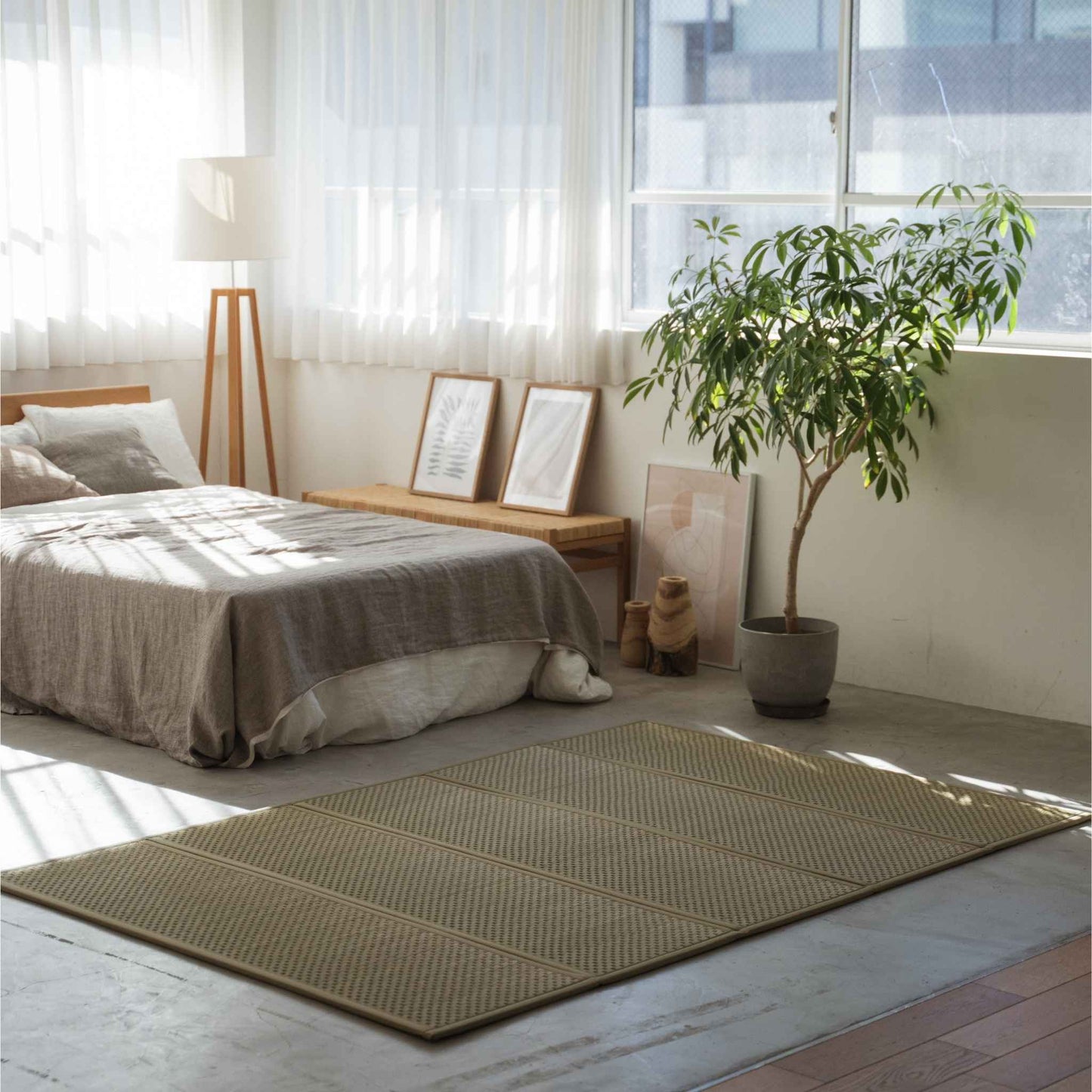Dobbelt størrelse tatami måtte spredt på et solbeskinnet soveværelsesgulv, der skaber et naturligt meditationsrum og en zen-stemning.