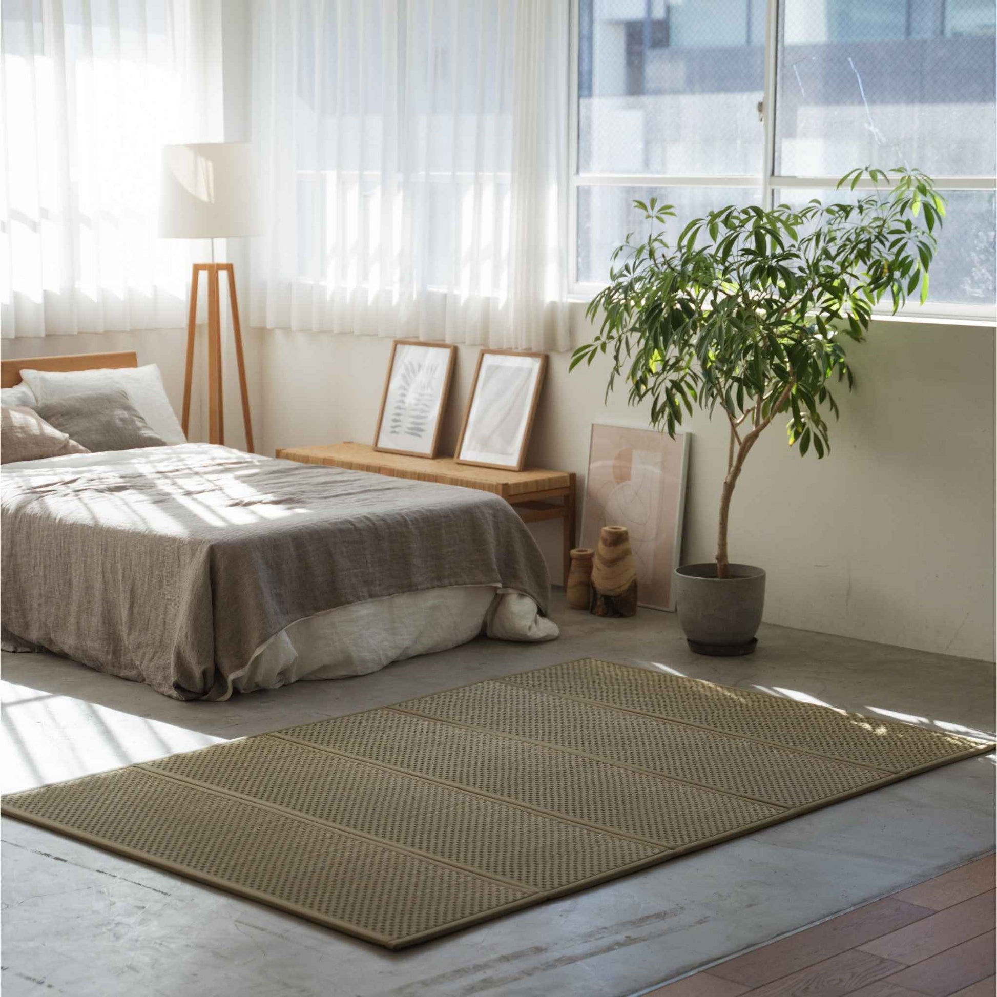 Dobbelt størrelse tatami måtte spredt på et solbeskinnet soveværelsesgulv, der skaber et naturligt meditationsrum og en zen-stemning.