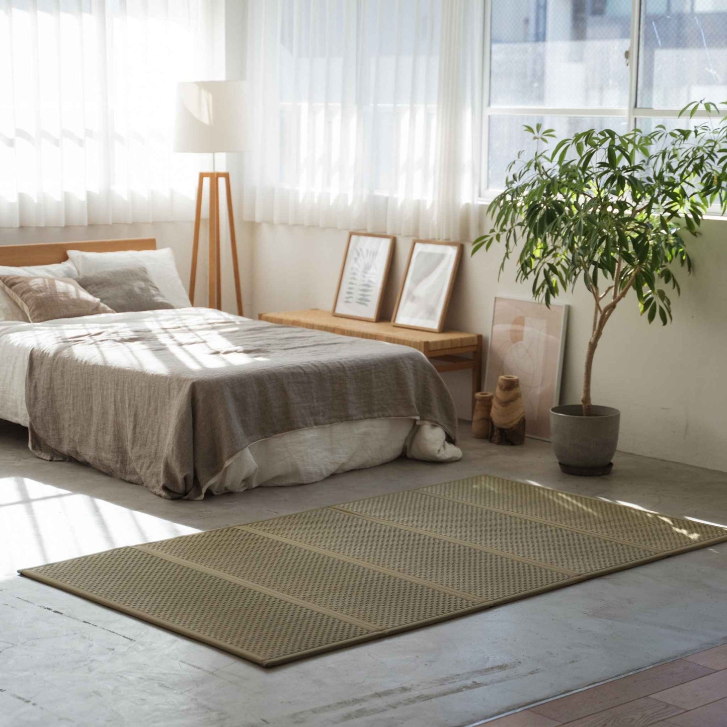 Halv-dobbelt tatami måtte madras på et gulv i et solrigt rum, der fungerer som en fugtregulerende base for en futon.