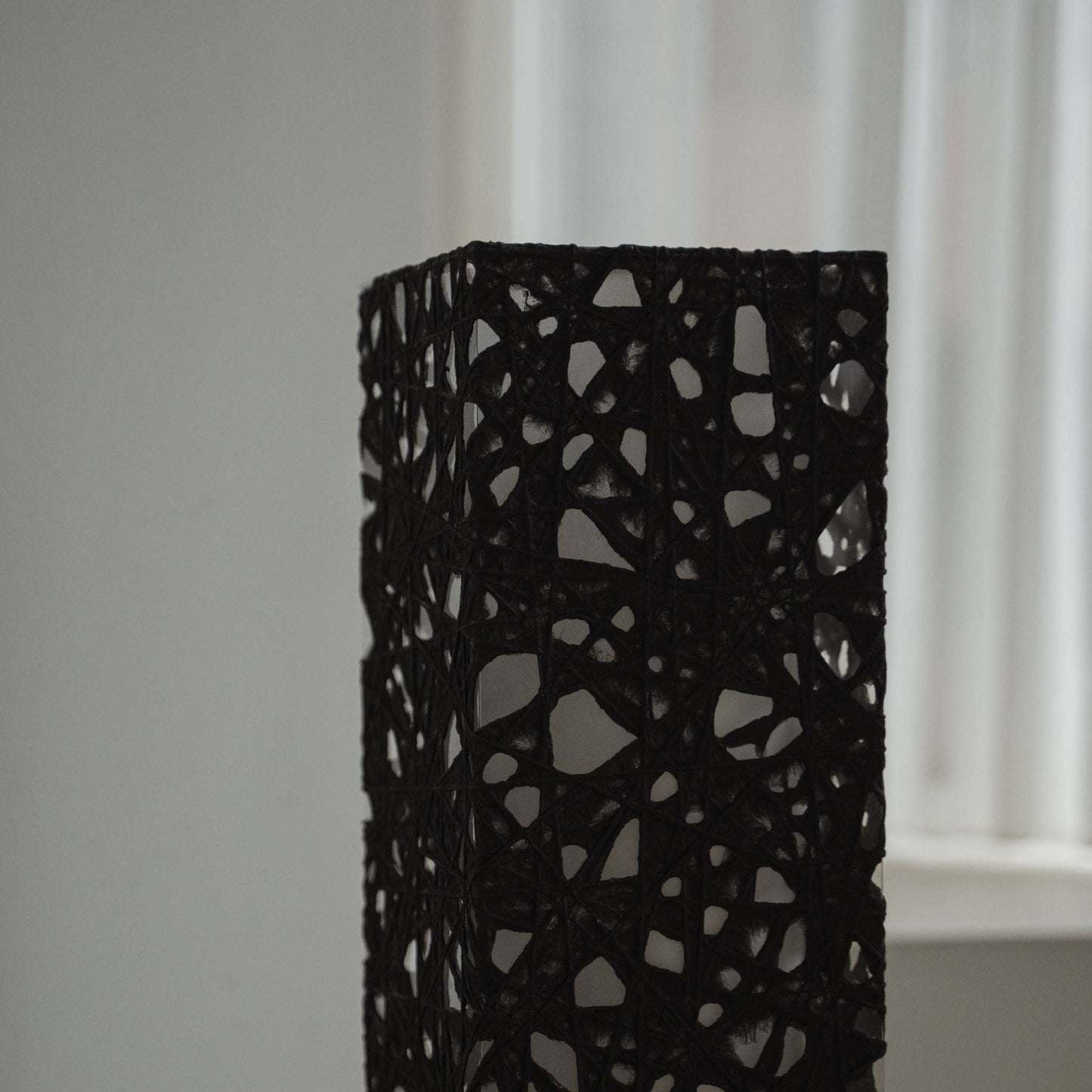 Gros plan sur la texture du papier noir Melook avec des fibres de Kozo semblables à des toiles sur l'abat-jour Me Look 01.
