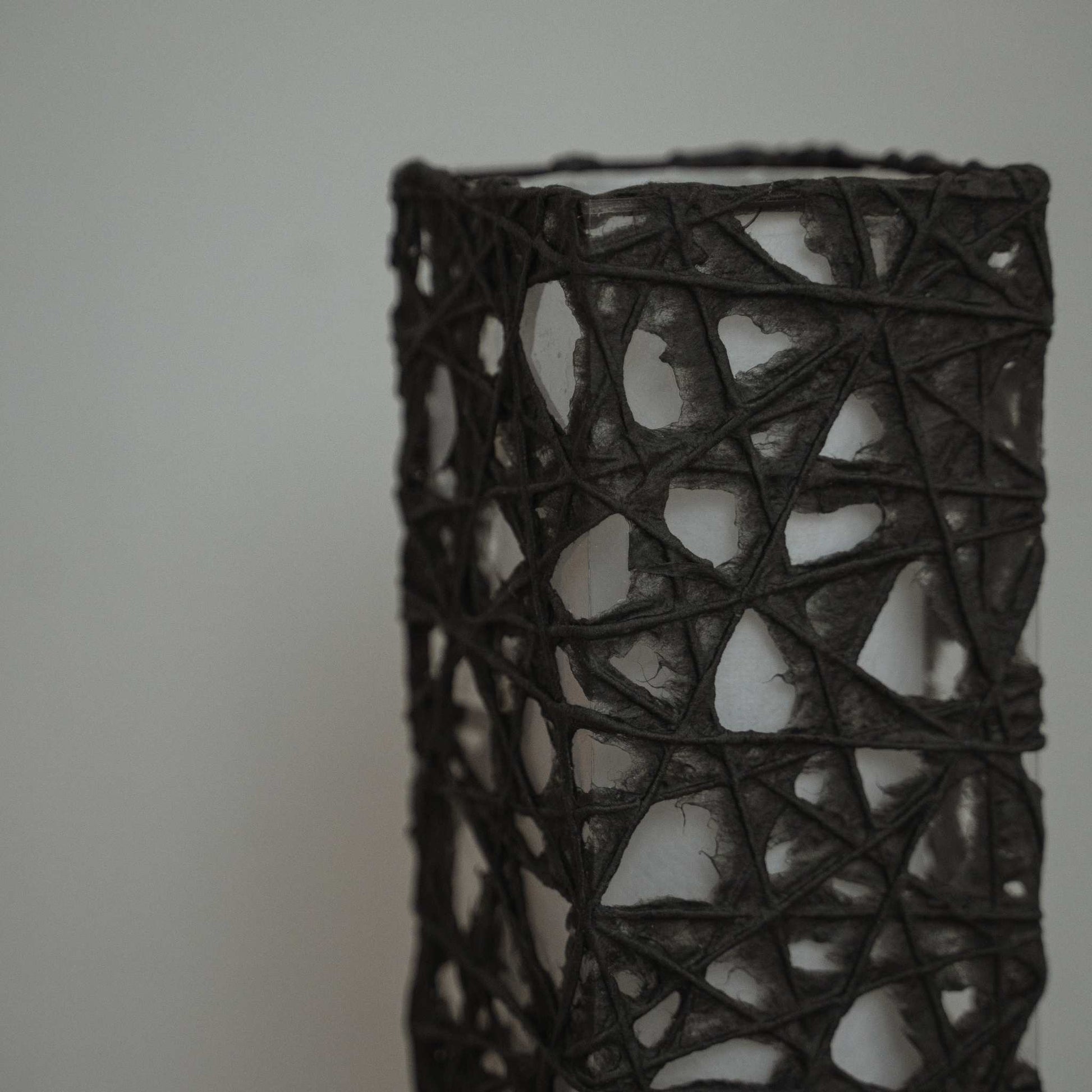 Détail de la texture du papier noir Me-look montrant des fibres de Kozo entrelacées comme une toile sur l'abat-jour Me Look 02.
