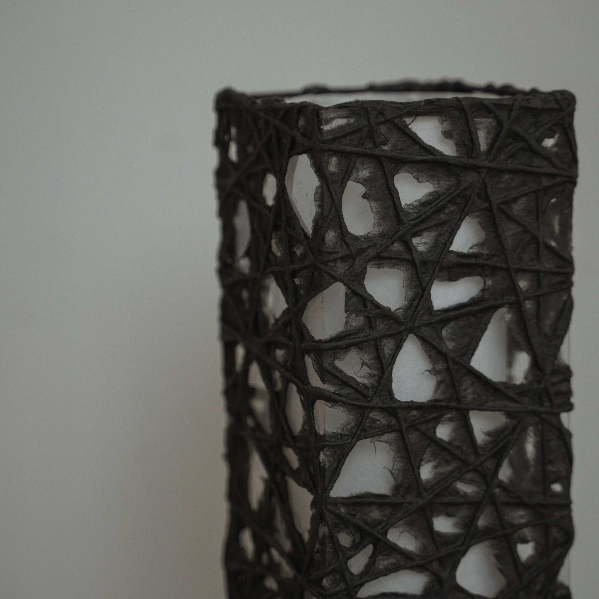 Détail de la texture du papier noir Me-look montrant des fibres de Kozo entrelacées comme une toile sur l'abat-jour Me Look 02.