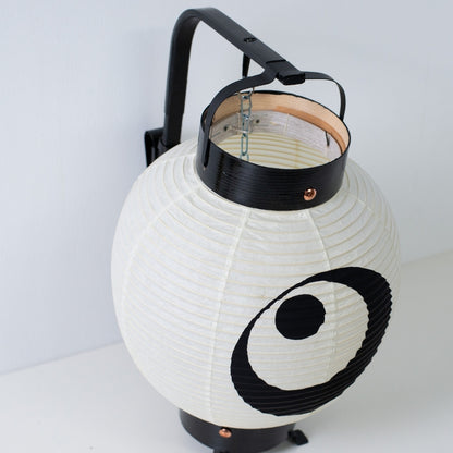 Hoge hoek weergave van een kleine Japanse lantaarn die de interne bamboe boogstructuur en zwart gelakte houten frames toont.