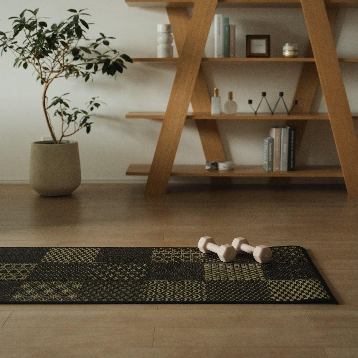 Japanse Tatami Yogamat "Ed Plain" Zwart met dumbbells in een woonkamer in Japandi-stijl voor een moderne thuisworkout.