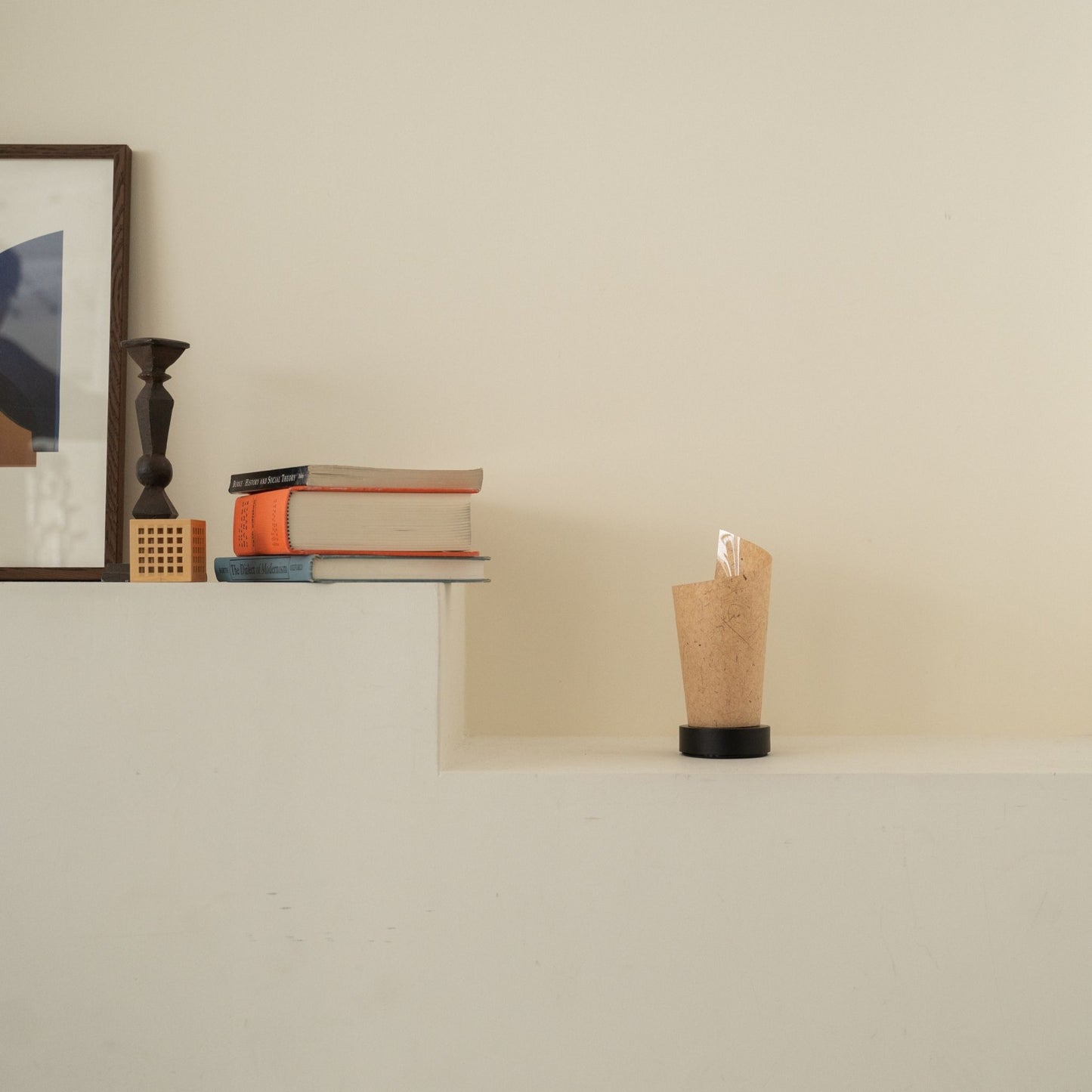 Lampe de table japonaise non allumée "Maki" en écorce de cèdre avec des marbrures rustiques sur une console blanche dans un salon Japandi.