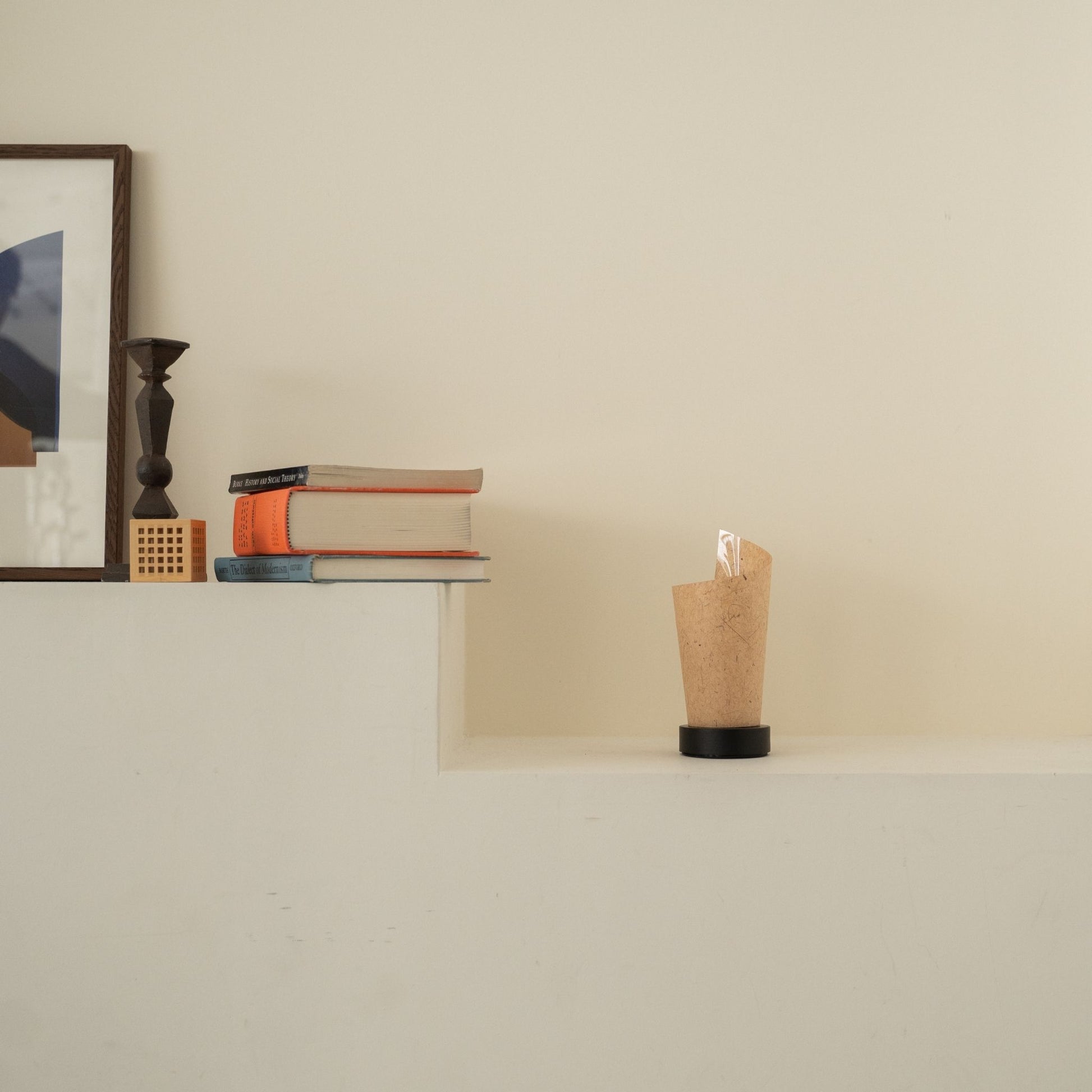 Lampe de table japonaise non allumée "Maki" en écorce de cèdre avec des marbrures rustiques sur une console blanche dans un salon Japandi.