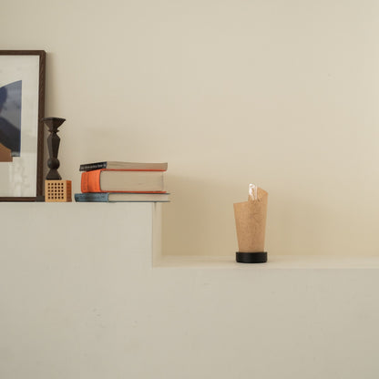Lampe de table japonaise non allumée "Maki" en écorce de cèdre avec des marbrures rustiques sur une console blanche dans un salon Japandi.