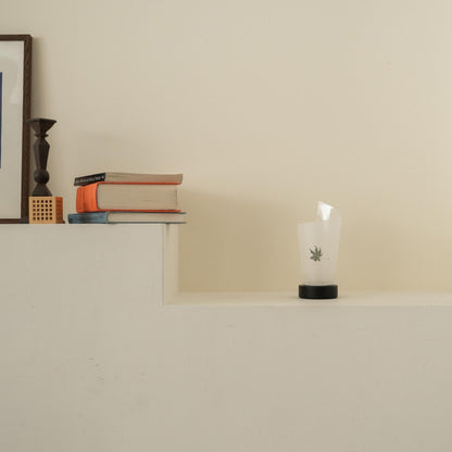 Lampe de table japonaise non allumée en papier "Maki" Feuille Momiji avec des marbrures rustiques sur une console blanche dans un salon Japandi.