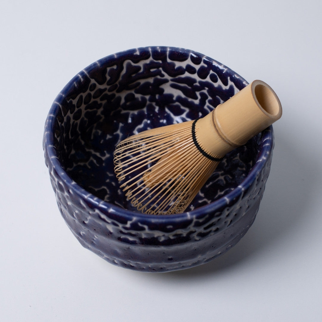 Indvendigt billede af den japanske matcha-skål "Midnight Blue Kairagi" med en bambus-tepisker, der viser den dybe blå farve til meditative te-ritualer.