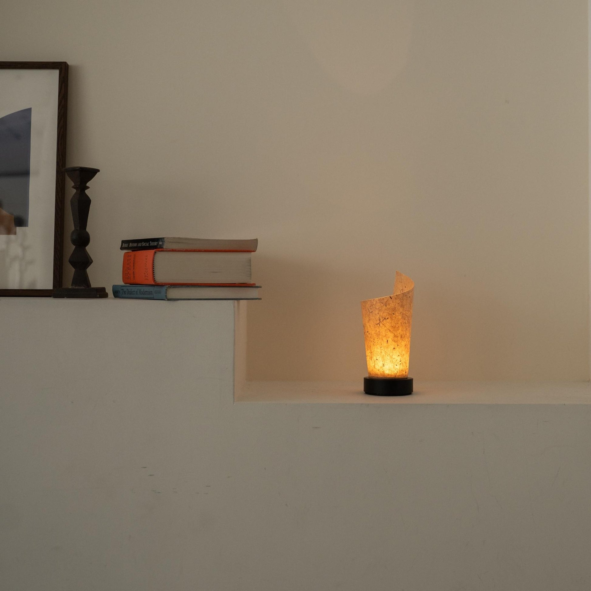"Lampe de table japonaise en papier "Maki" en écorce de cèdre, éclairant chaleureusement comme une lampe d'ambiance sur une console blanche dans un salon Japandi."