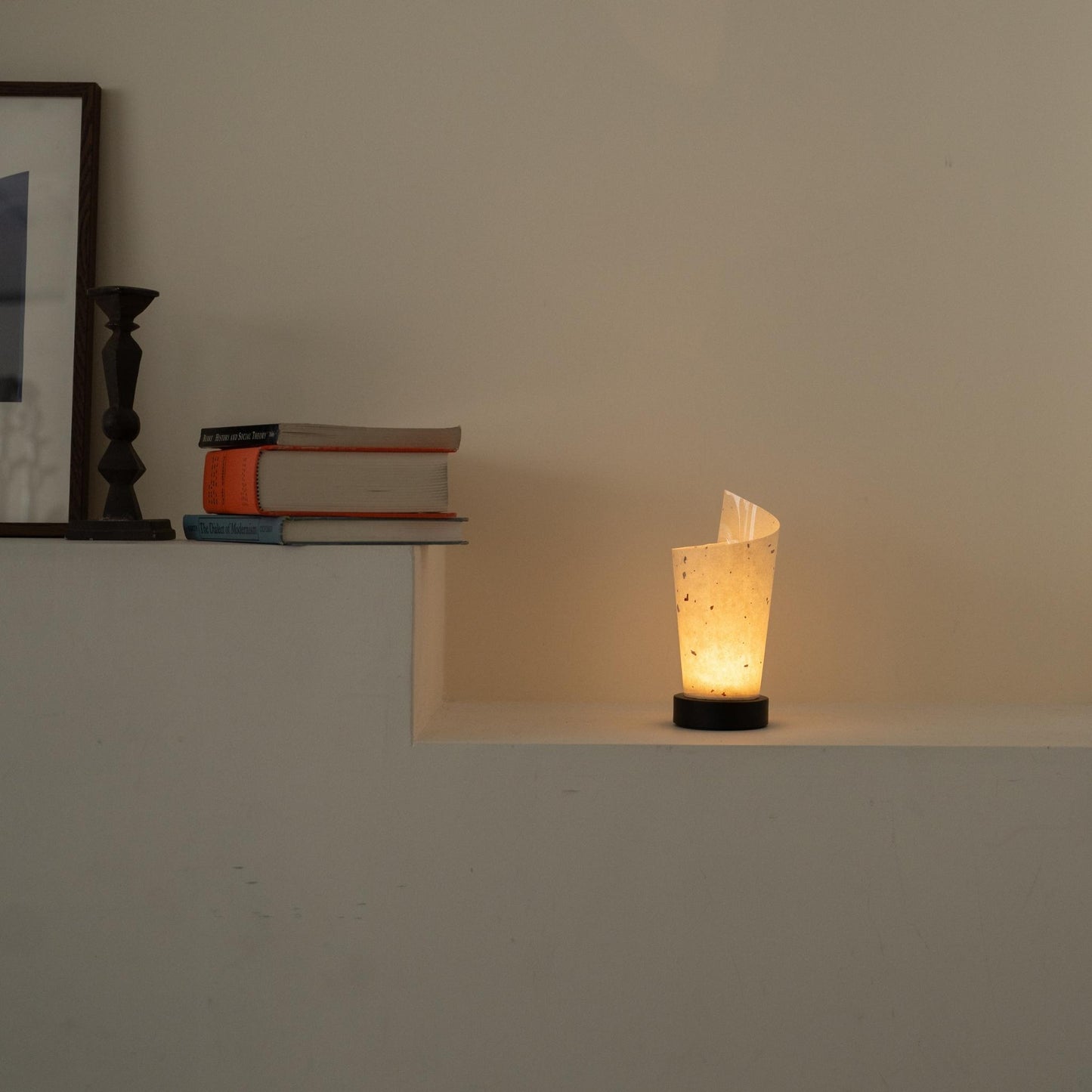 "Lampe de table japonaise en papier "Maki" éclairant chaleureusement comme une lampe d'ambiance sur une console blanche dans un salon Japandi."