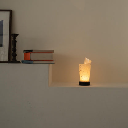 "Lampe de table japonaise en papier "Maki" éclairant chaleureusement comme une lampe d'ambiance sur une console blanche dans un salon Japandi."
