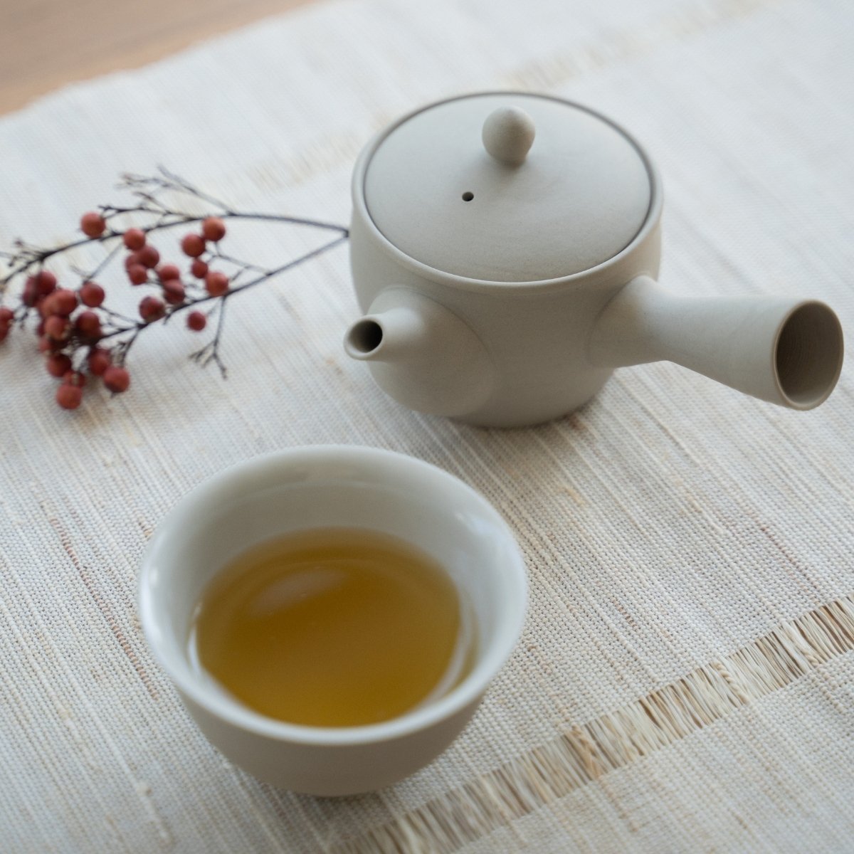 White Japanese tea set "Fuyo" with brewed tea on a linen mat for tea enthusiasts savoring a calming solo ritual.