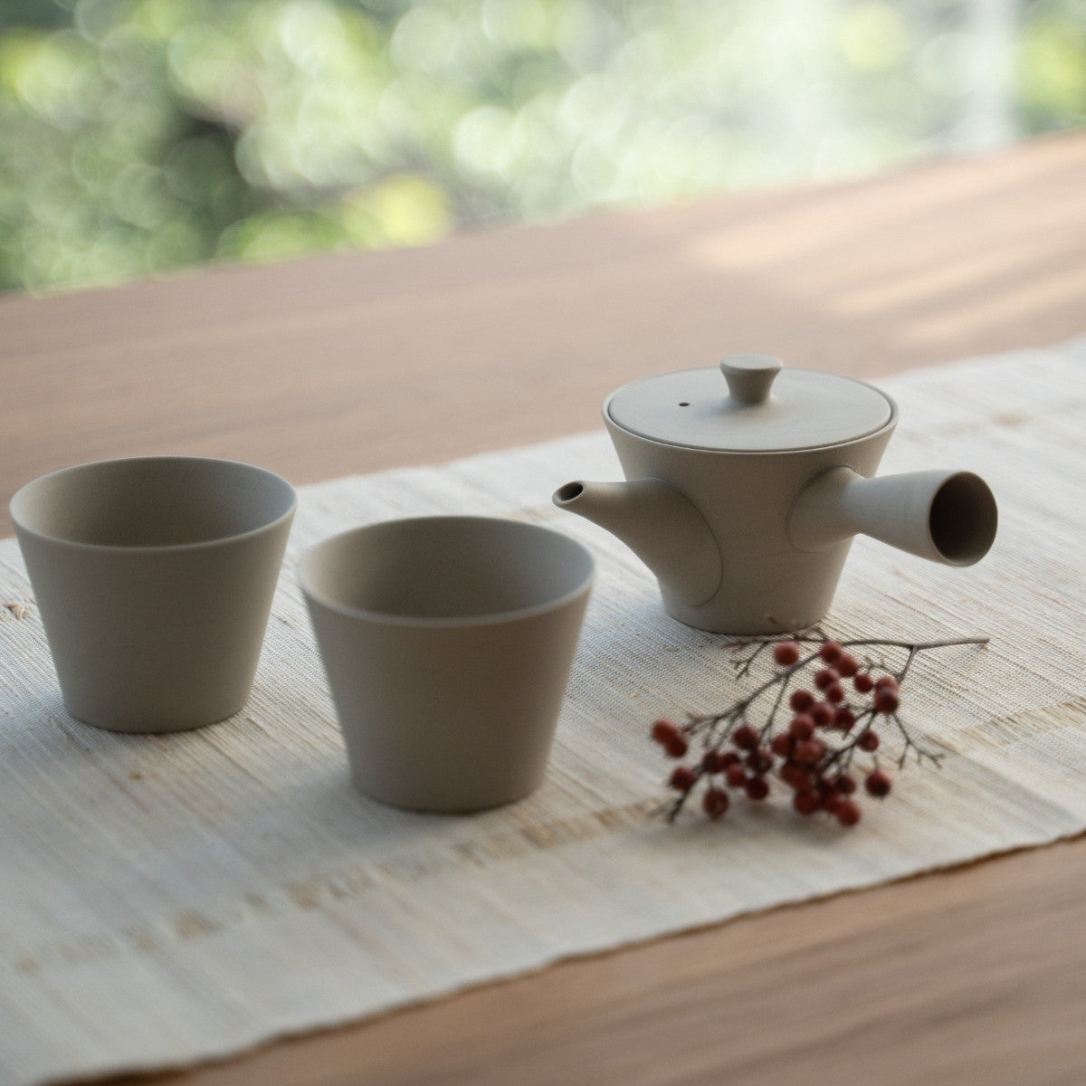 White Japanese teapot "Sencha" and Japanese tea cups on a linen mat for tea lovers creating a zen aesthetic.