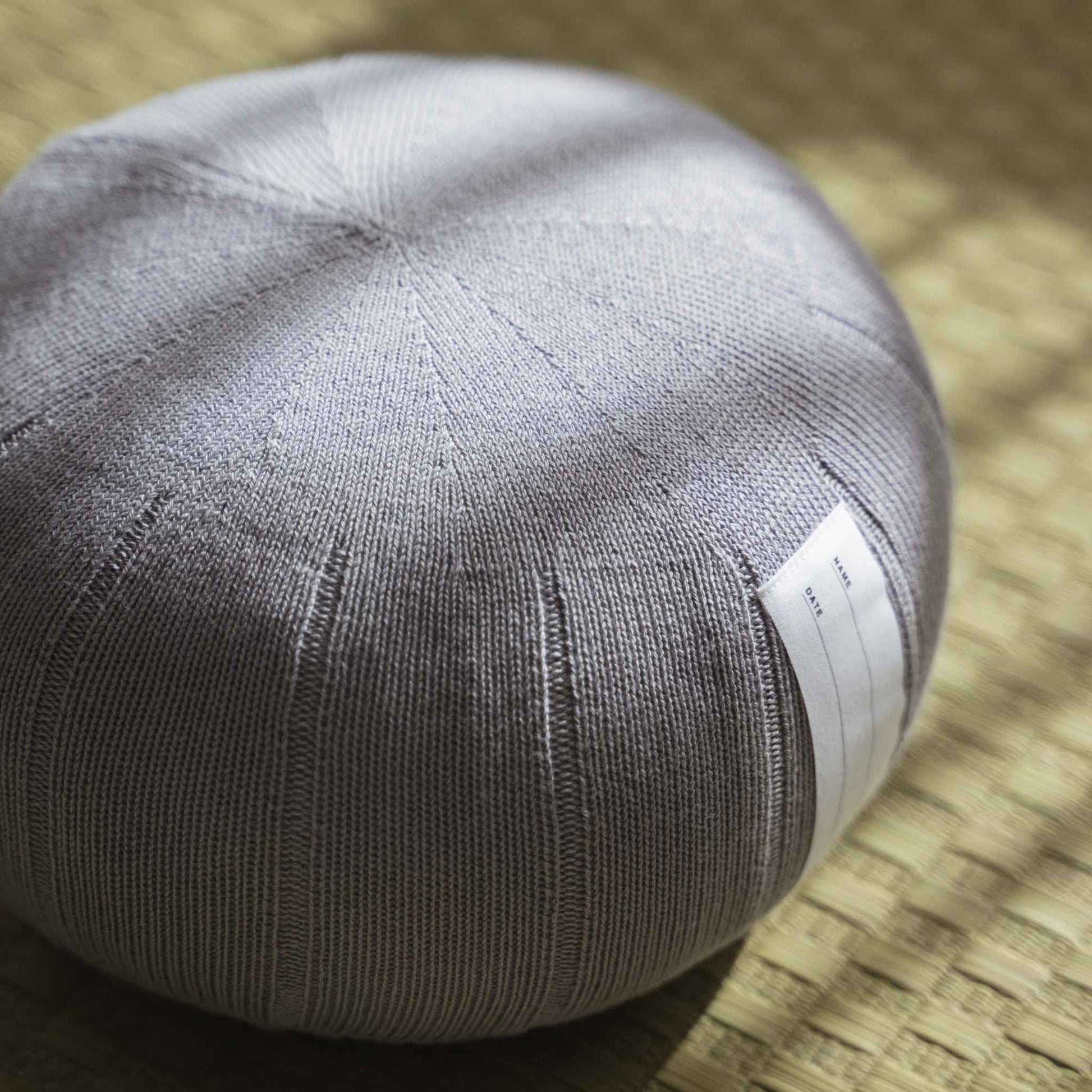 Lagoon grå zafu meditationspude håndlavet af økologisk bomuld placeret på en traditionel tatami-måtte.