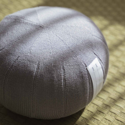 Lagoon grå zafu meditationspude håndlavet af økologisk bomuld placeret på en traditionel tatami-måtte.