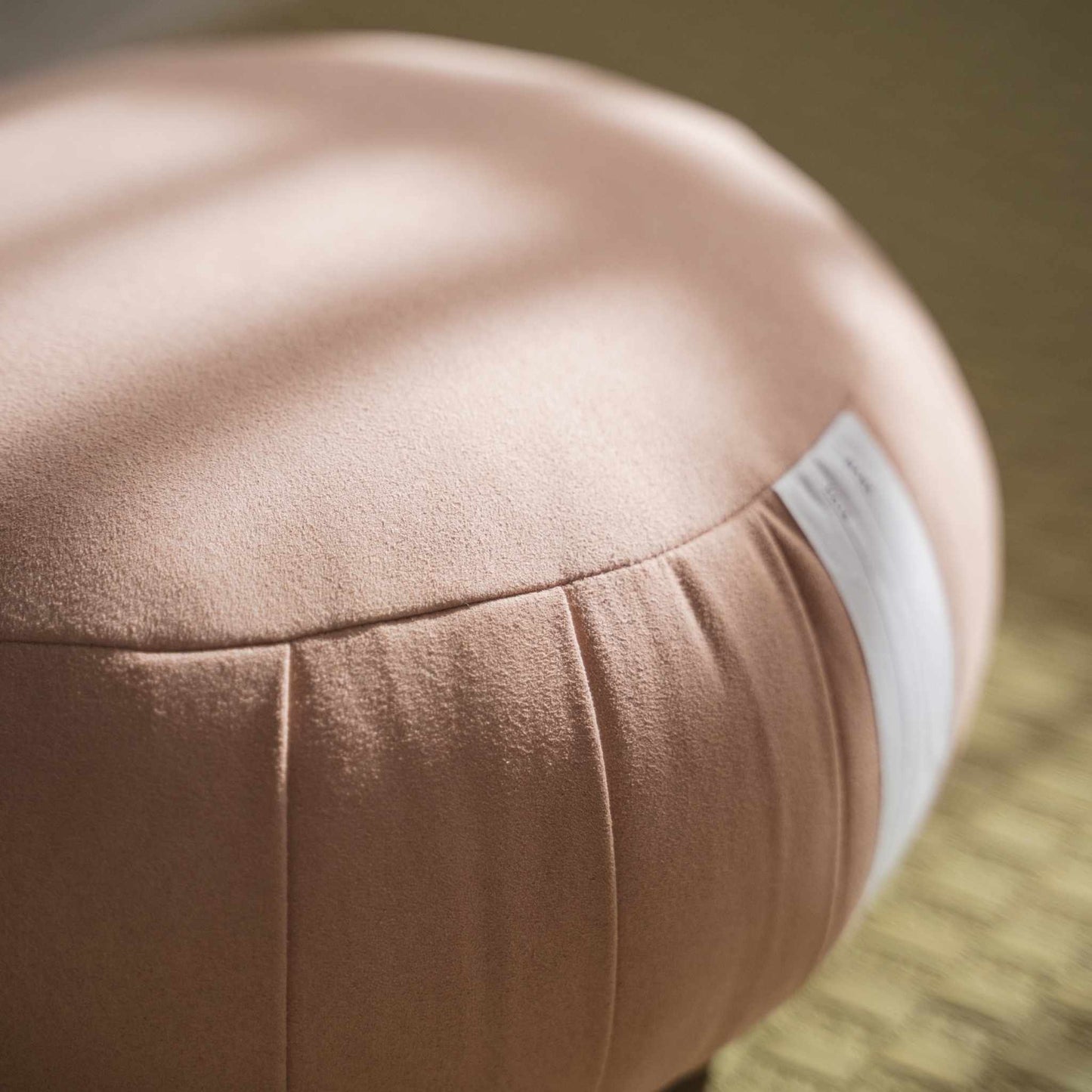 Gros plan d'un coussin de méditation zafu rose fumé montrant la texture du tissu de haute qualité et sa forme ferme.